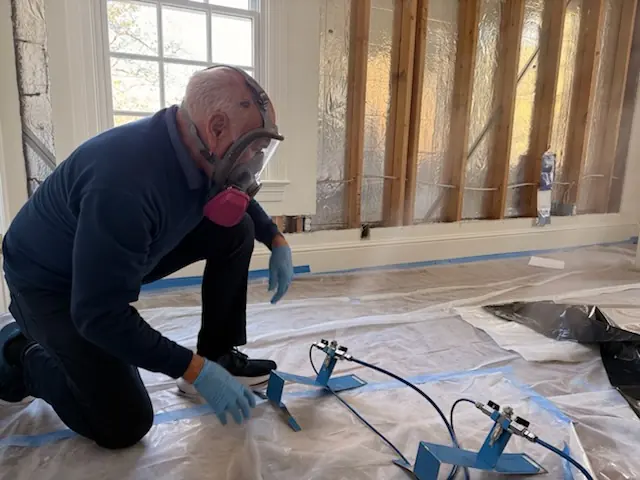 A restoration technician setting drying equipment in an Riverside home stripped to the studs
