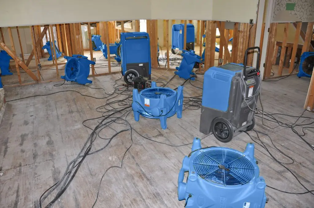 Air movers drying a gutted Riverside room after major water damage